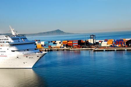 A cruise ship coming into port at ensenada, Mexico with shipping containers in the background