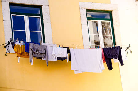 Clothes hanging from an apartment building in the Alfama District of Lisbon Portugalの写真素材