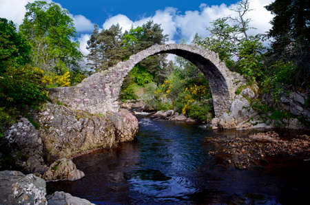 Ancient curved Carr Bridge in Scotlandの写真素材