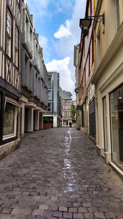 A cobblestone street with store fronts on each side in Rouen France.の写真素材