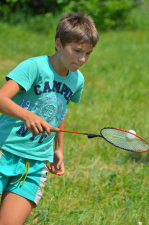 VORONEZH REGION / RF - JUNE 2019: funny sport contest in a children's summer camp. A nimble boy holds a light ball on the badminton racketのeditorial素材