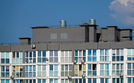 Urban high-rise apartment building with windows and many air conditioners