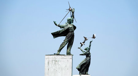 Kiev, Ukraine July 12, 2020: sculpture Men and women standing on the bridge over which the metro...