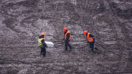 Kiev, Ukraine, October 17, 2018: Workers in the mud of a construction site at the stage of excavation; construction of a supermarket AUCHANのeditorial素材