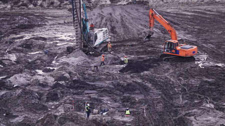 Kiev, Ukraine, October 17, 2018: Workers in the mud of a construction site at the stage of excavation; construction of a supermarket AUCHANのeditorial素材