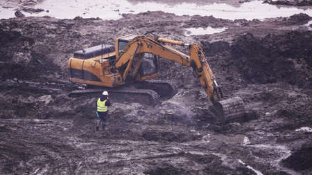 Kiev, Ukraine, October 17, 2018: Workers in the mud of a construction site at the stage of excavation; construction of a supermarket AUCHANのeditorial素材