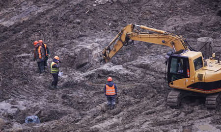 Kiev, Ukraine, October 17, 2018: Workers in the mud of a construction site at the stage of excavation; construction of a supermarket AUCHANのeditorial素材