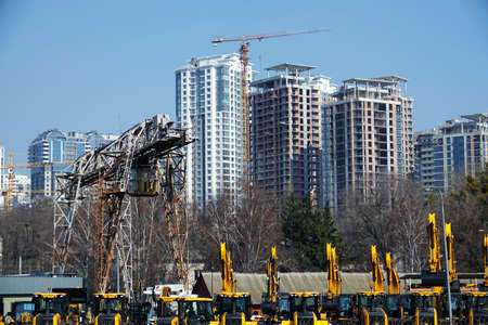 Kiev, Ukraine March 18, 2020: Tractors and excavators for sale on the background of houses under constructionのeditorial素材