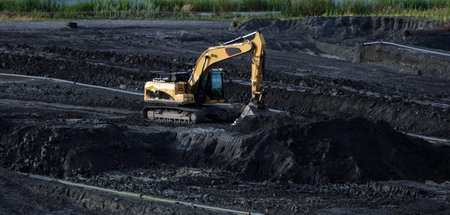 Kiev, Ukraine March 18, 2020: Working excavator digging black soil soil