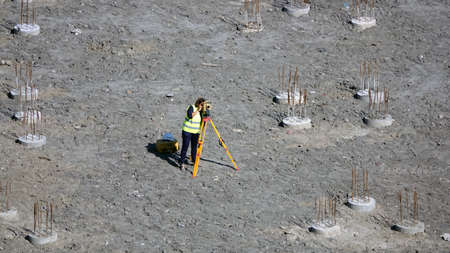 Kiev, Ukraine August 27, 2019: Woman surveyor checks the level of installed piles.のeditorial素材