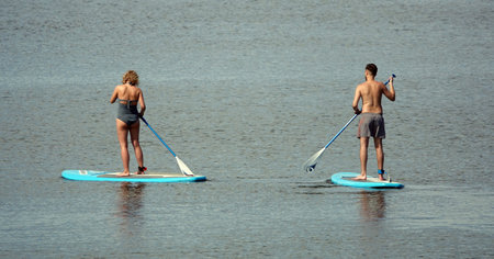 Kiev, Ukraine July 24, 2020: SUP-surfing man and woman ride on the river