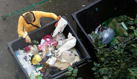 Kiev, Ukraine September 20, 2018: a homeless girl eats directly from the trash canのeditorial素材