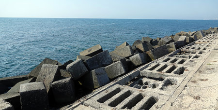 Embankment breakwater made of concrete and huge square concrete blocks