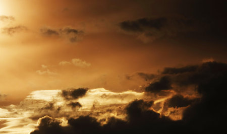 Sky with beautiful gloomy black clouds and a glare of the sun