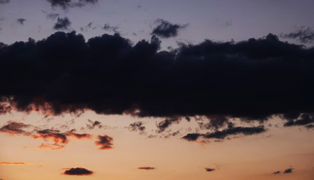 Sky with beautiful gloomy black clouds and a glare of the sunの写真素材