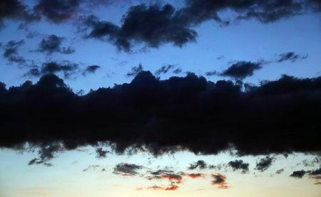 Sky with beautiful gloomy black clouds and a glare of the sun