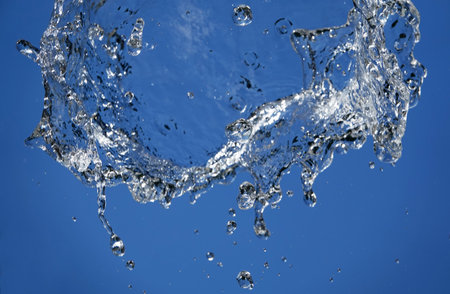 Background - Water in flight on a blue background takes on a variety of unique and bizarre shapesの写真素材