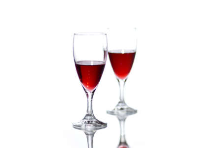 Two glasses of red wine on white background with reflection.の写真素材