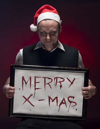 Horror Christmas Elf holding a sign written with blood.の写真素材