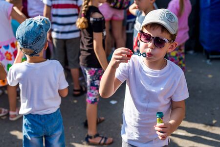 Volgodonsk, Russia-August 25, 2019: bubble show festival, art project ignite together.Holiday in the Park, the boy happily inflated and released into the sky a lot of bubbles and happily smilingのeditorial素材