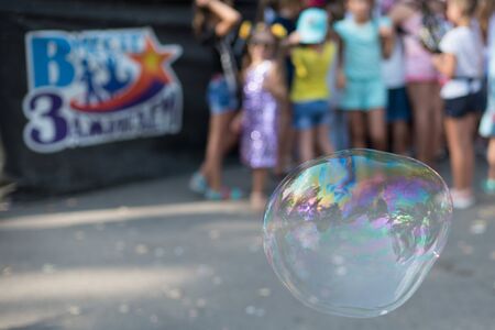 Volgodonsk, Russia-August 25, 2019: bubble show festival, art project ignite together.Holiday in the Park, a big bubble on the background of the scene and the crowd of childrenのeditorial素材