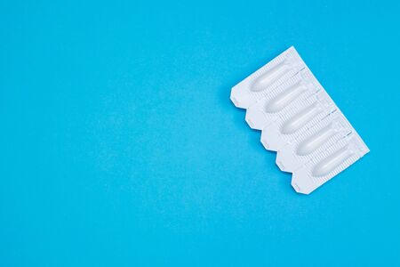 White suppositories for anal or vaginal use on blue background. Medical candles for the treatment of Candida, thrush, hemorrhoids, inflammation and fever. Effective drug. Copy spaceの写真素材