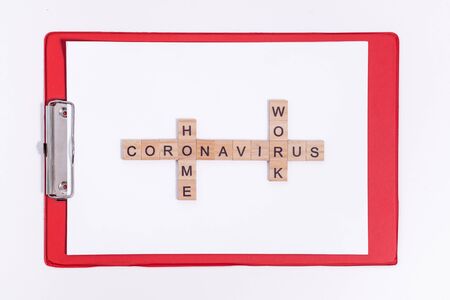 Text from wooden letters coronavirus work from home. Office red tablet on the desktop. Flatley layout isolated on a white background. Minimalistic office concept. Working during a virus pandemic.の写真素材