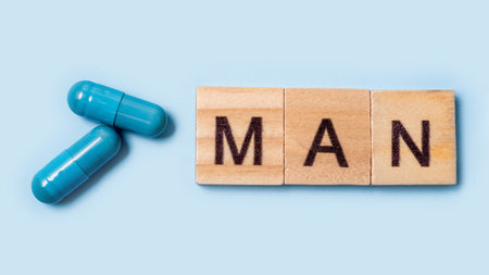 Banner. Two blue capsules and the inscription man. Pills for mens health and sexual energy on an isolated background. Concept of erection, potency. Treatment of male infertility and impotenceの写真素材