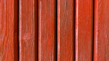 Old red wooden background of colored painted vertical boards in grunge style. Top view. Raw planed...
