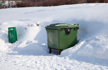 Green dumpster in the winter parkの写真素材