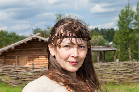 Young women on background of ancient traditional russian village X century