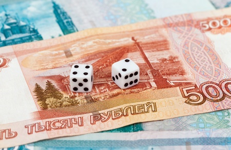 Two dice laying over a pile russian moneyの写真素材