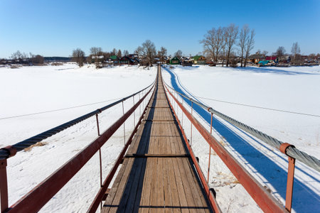 Suspension foot bridge over the frozen river