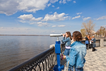 SAMARA, RUSSIA - MAY 1: Girl looks through the coin operated binocular on the banks of the Volga River on May 1, 2013 in Samara, Russia. Volga river is one of the largest rivers in Europeのeditorial素材