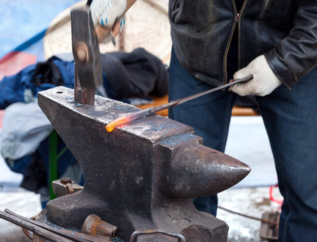 Blacksmith forges iron in the forge