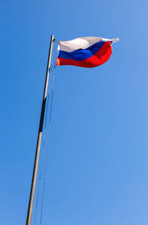Russian flag waving in the wind over blue skyの写真素材
