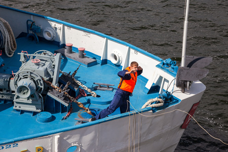 SAMARA, RUSSIA - AUGUST 31, 2014: Sailor throws a rope for mooring the river cruise passenger ship S. Yulaev on Volga river in Samaraのeditorial素材