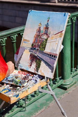 SAINT PETERSBURG, RUSSIA - AUGUST 9, 2014: Artist paint Church of the Savior on Spilled Blood in sunny dayのeditorial素材