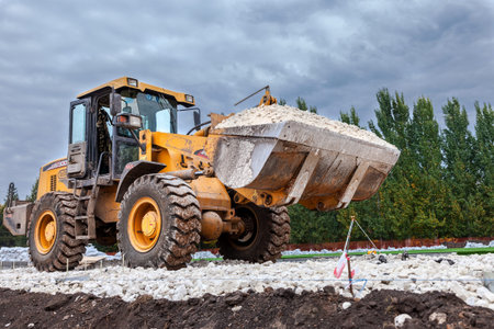 SAMARA, RUSSIA - SEPTEMBER 28, 2014: Heavy bulldozer loading and moving gravel on road construction...