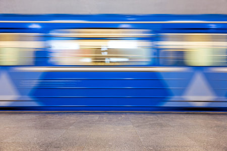 Blue subway train in motion at the station