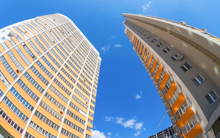 Tall apartment buildings under construction against a blue sky backgroundのeditorial素材