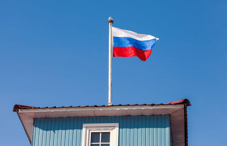 Russian flag waving in the wind over blue skyの写真素材