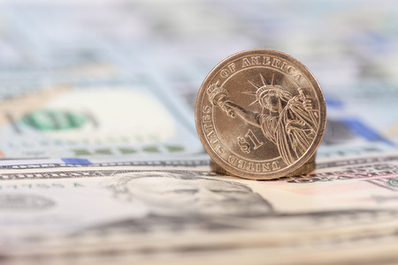 One American dollar coin over banknotes close upの写真素材