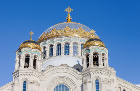 Golden domes with cross of Kronstadt Naval cathedral against blue sky