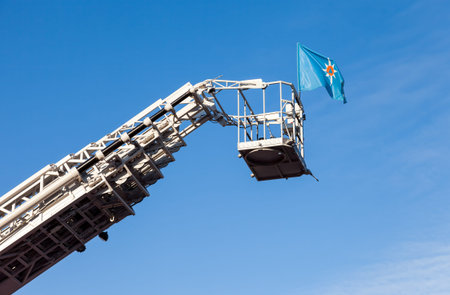 SAMARA, RUSSIA - NOVEMBER 7, 2015: Flag of the Russian Ministry of Emergency Situations fluttering on the retractable fire escapeのeditorial素材