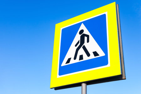 Traffic sign pedestrian crossing with blue sky in backgroundの写真素材