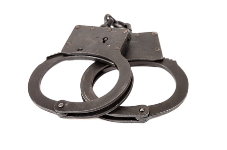 Steel black handcuffs over white backgroundの写真素材
