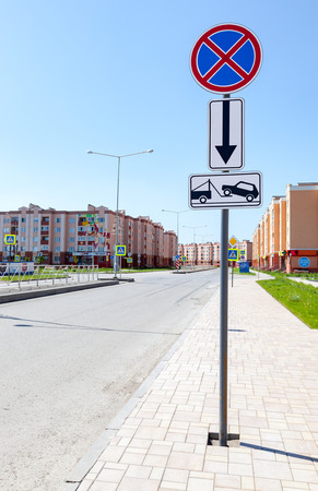 SAMARA, RUSSIA - MAY 29, 2016: Traffic sign prohibiting parking. Evacuation on tow truck with apartment buildings in background in summer dayのeditorial素材
