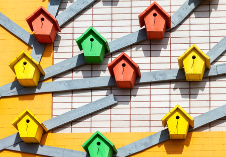 Colourful wooden birdhouses mounted on the brick wallの写真素材