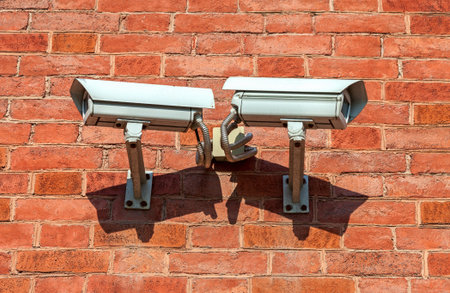 Surveillance cameras mounted on the wall of the buildingの写真素材